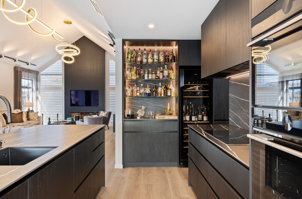 Hallmark Homes Oakbridge luxury kitchen with built-in bar, spiral pendant lighting, and premium appliances - Christchurch designer home builder