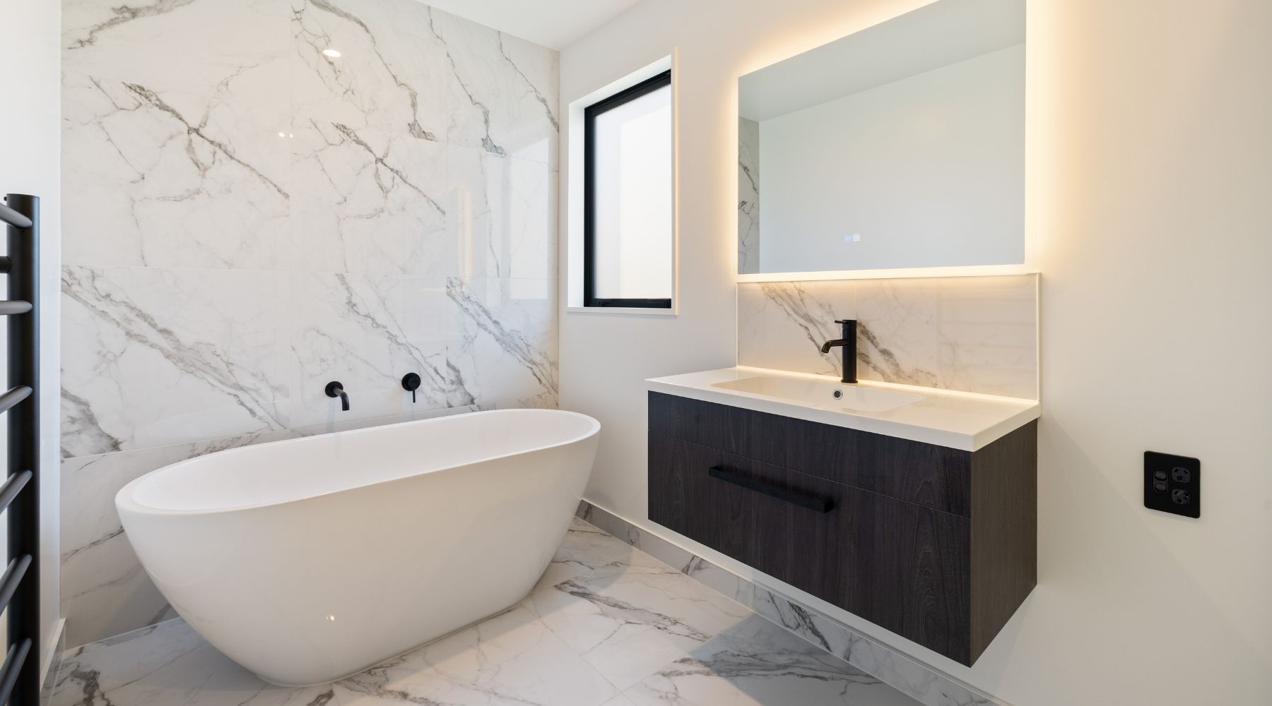 Hallmark Homes bathroom featuring black and white marble-look tiles with a dark timber vanity — custom Christchurch home.