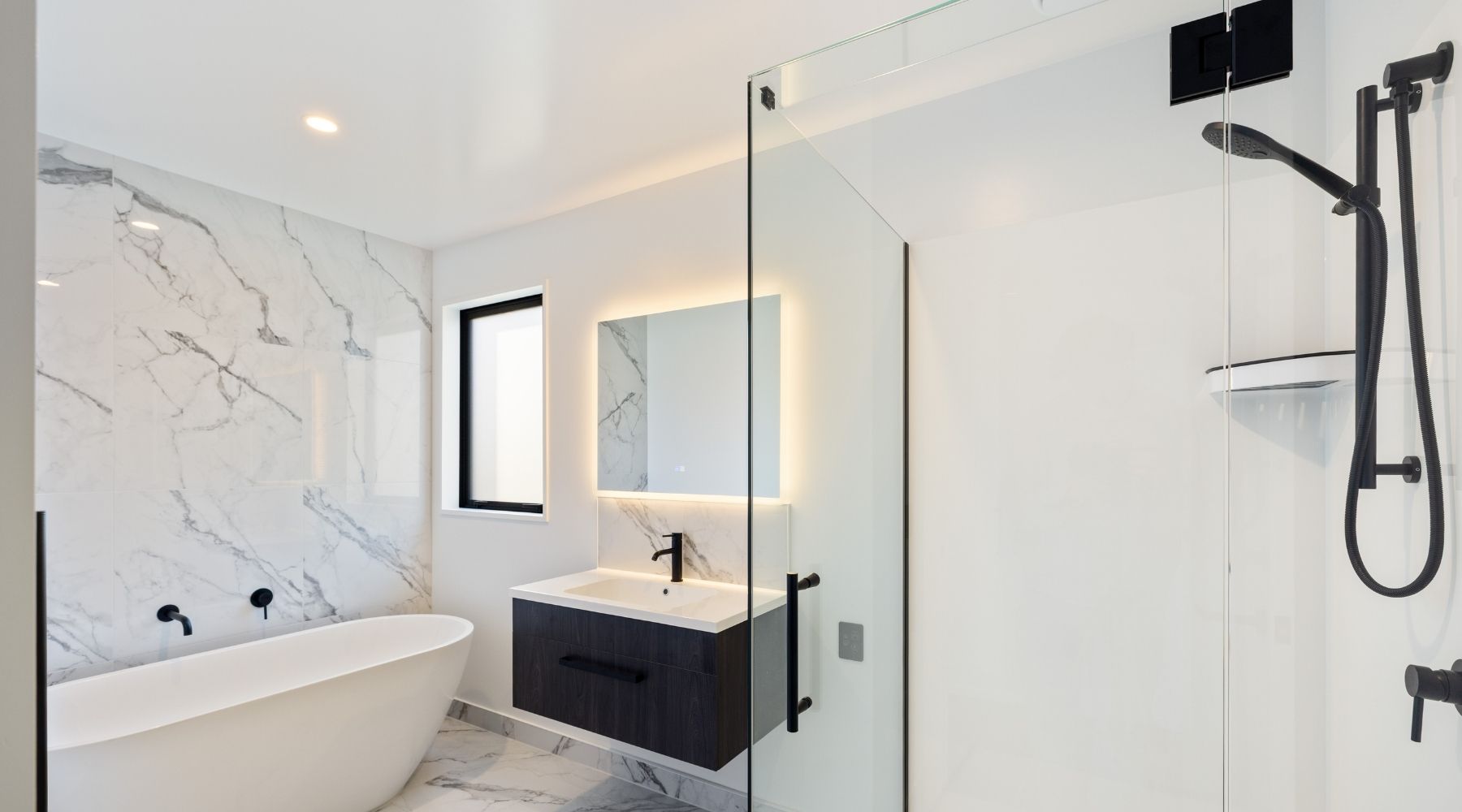 Hallmark Homes bathroom featuring black and white marble-look tiles with a dark timber vanity — custom Christchurch home.