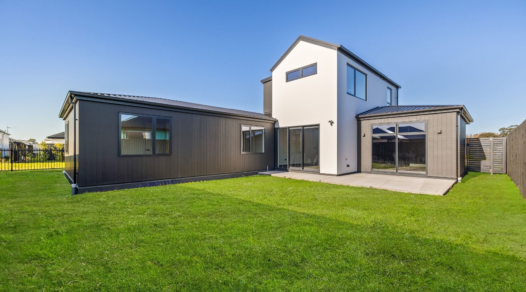 Back view of a Hallmark Homes build in Christchurch, featuring black Axon cladding and white plaster.