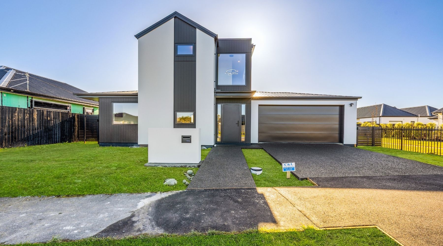 Front view of a Hallmark Homes two-storey build with white plaster and black cladding, designed and built in Christchurch.
