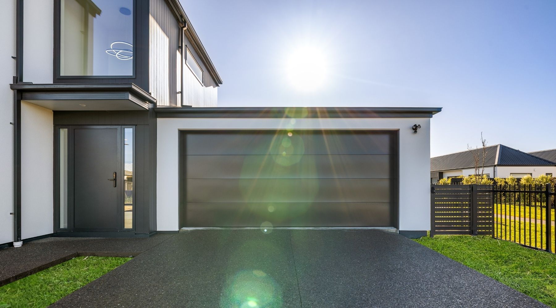 Contemporary home exterior in Christchurch with monochrome plaster and cladding, designed by Hallmark Homes.