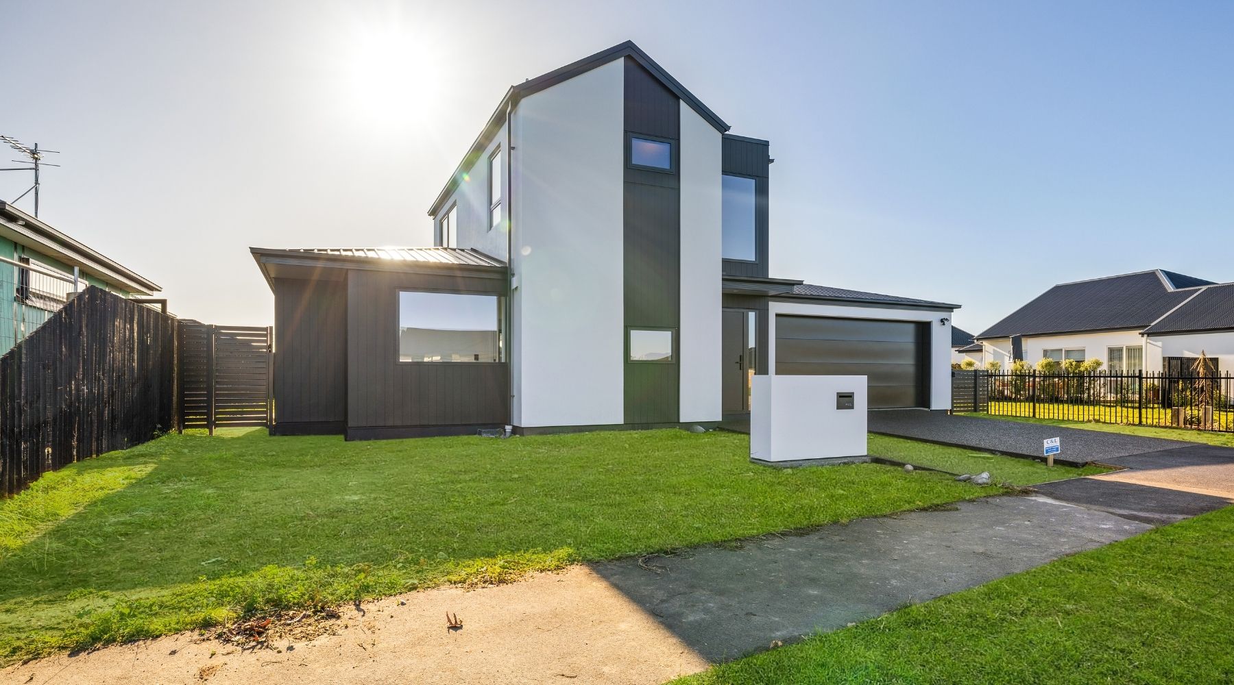 Modern Christchurch home by Hallmark Homes featuring white plaster and black feature cladding — architectural design and build.