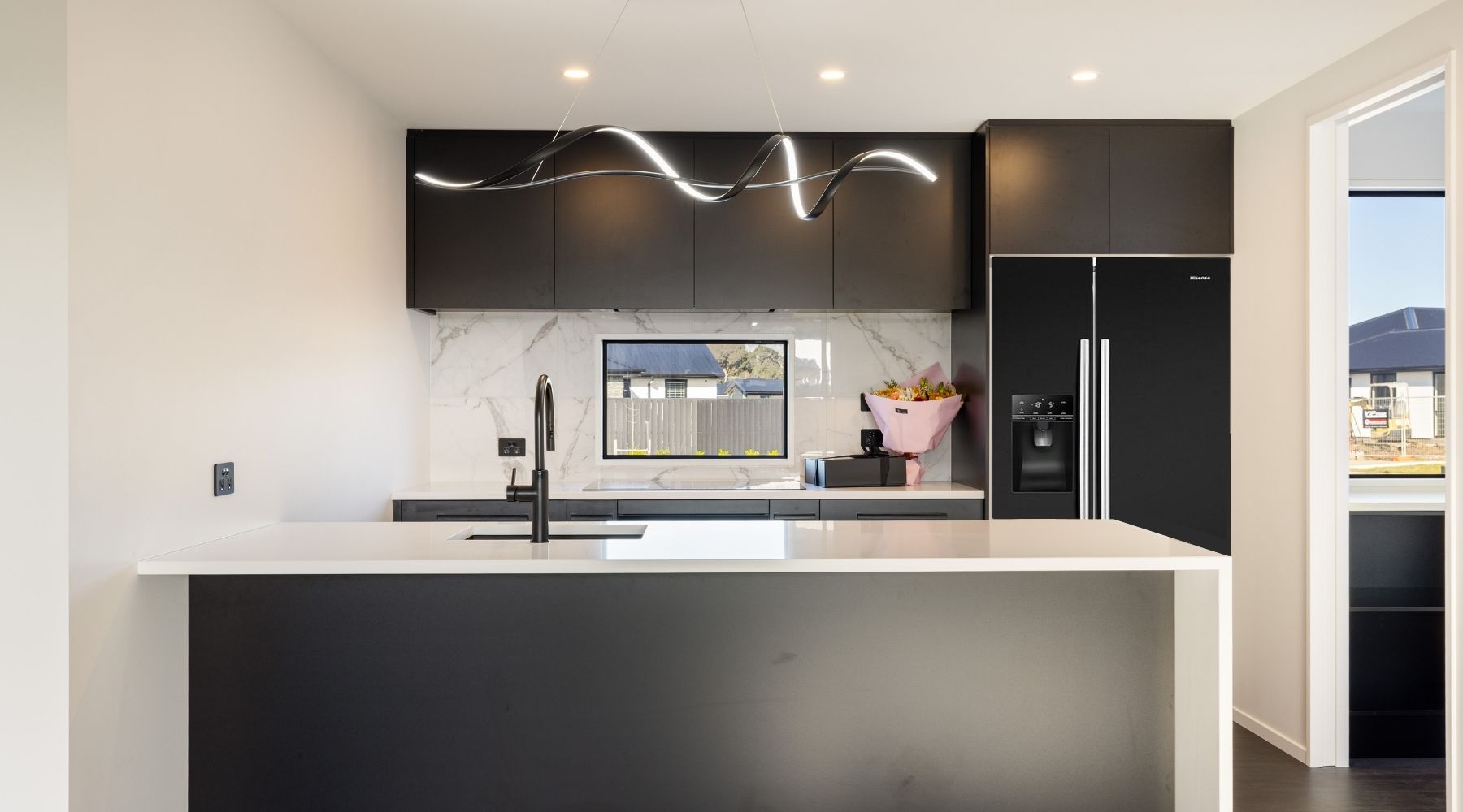 Hallmark Homes bespoke kitchen with black cabinetry and marble splashback — design and build project in Canterbury.
