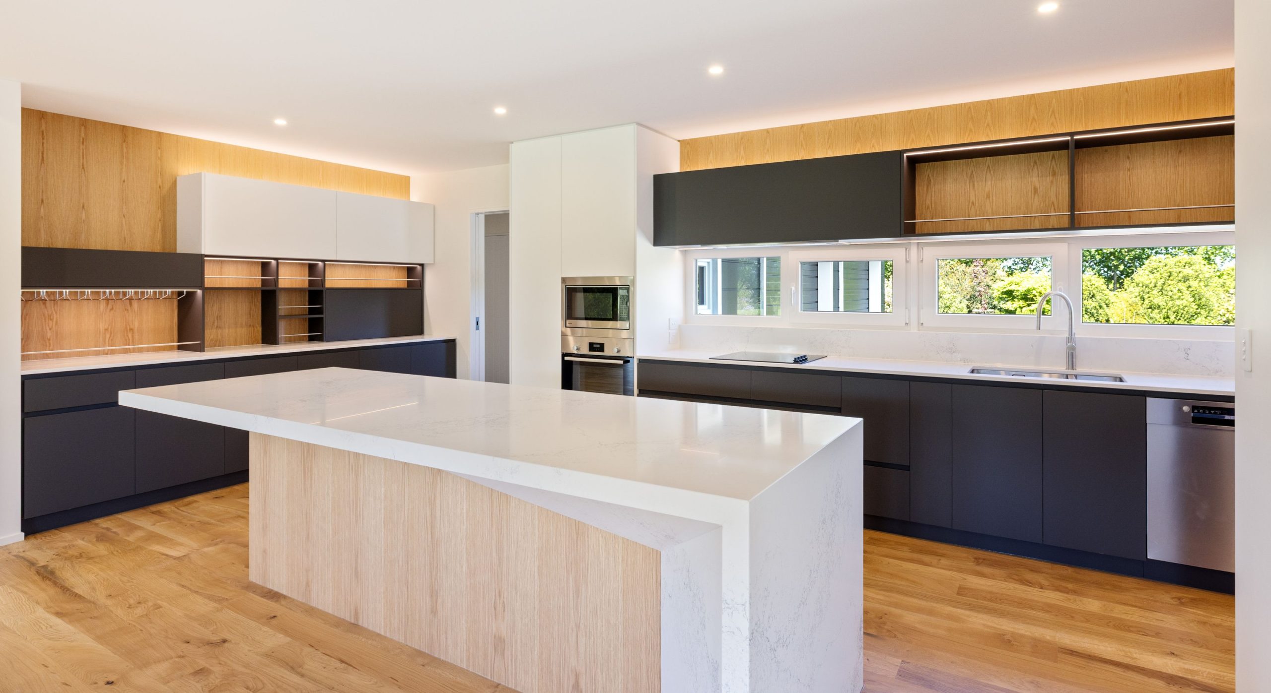 Open kitchen with natural, light and dark features and breakfast bar custom shaped