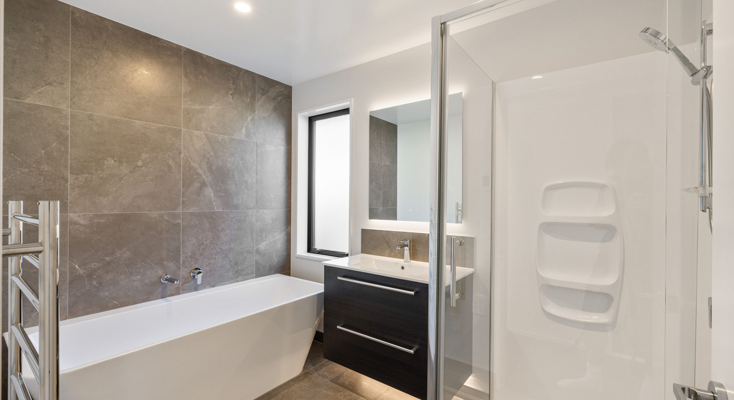 Neutral feature tiled wall in main bathroom