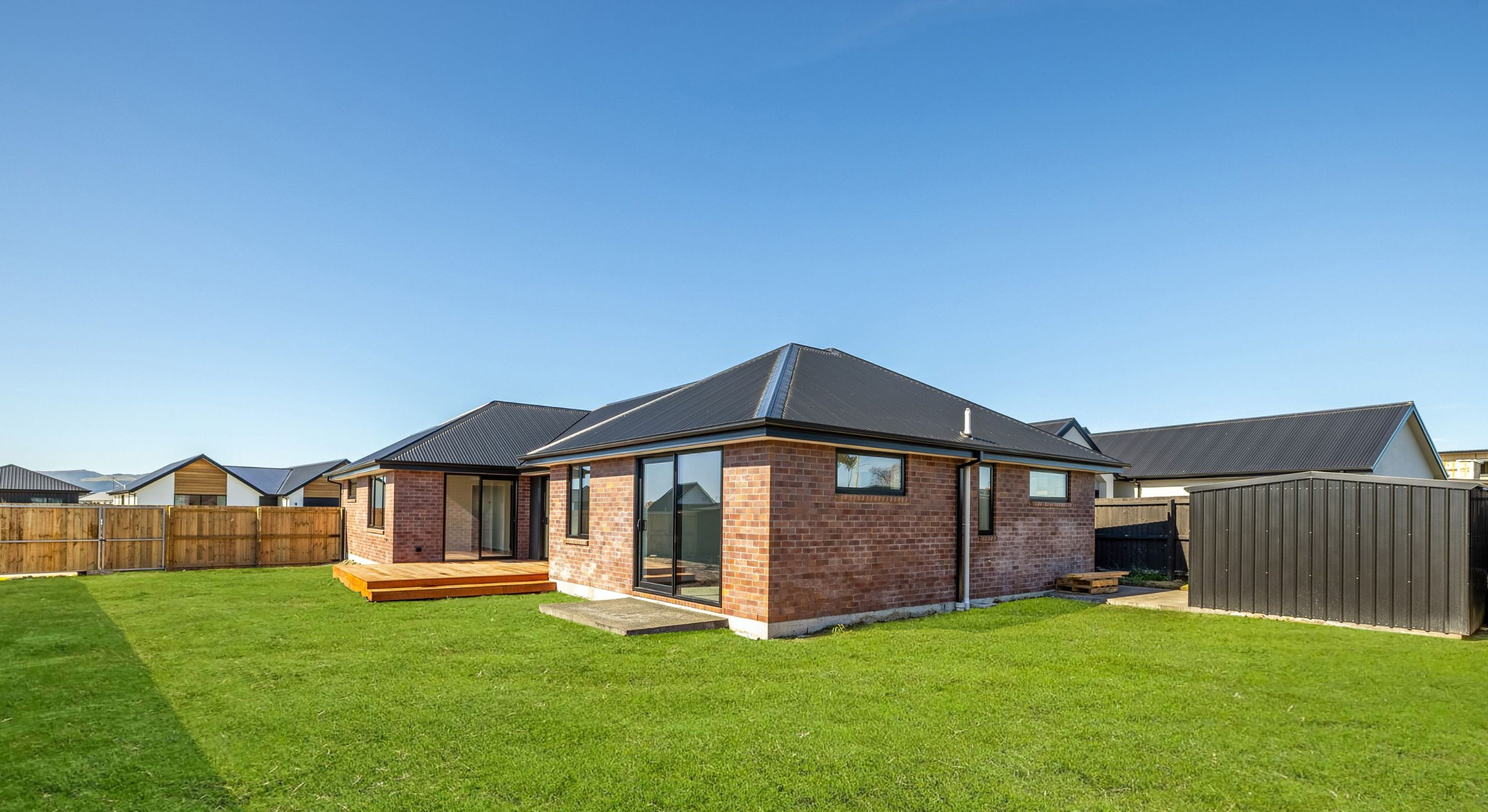 red brick with dark exterior features and nice back yard