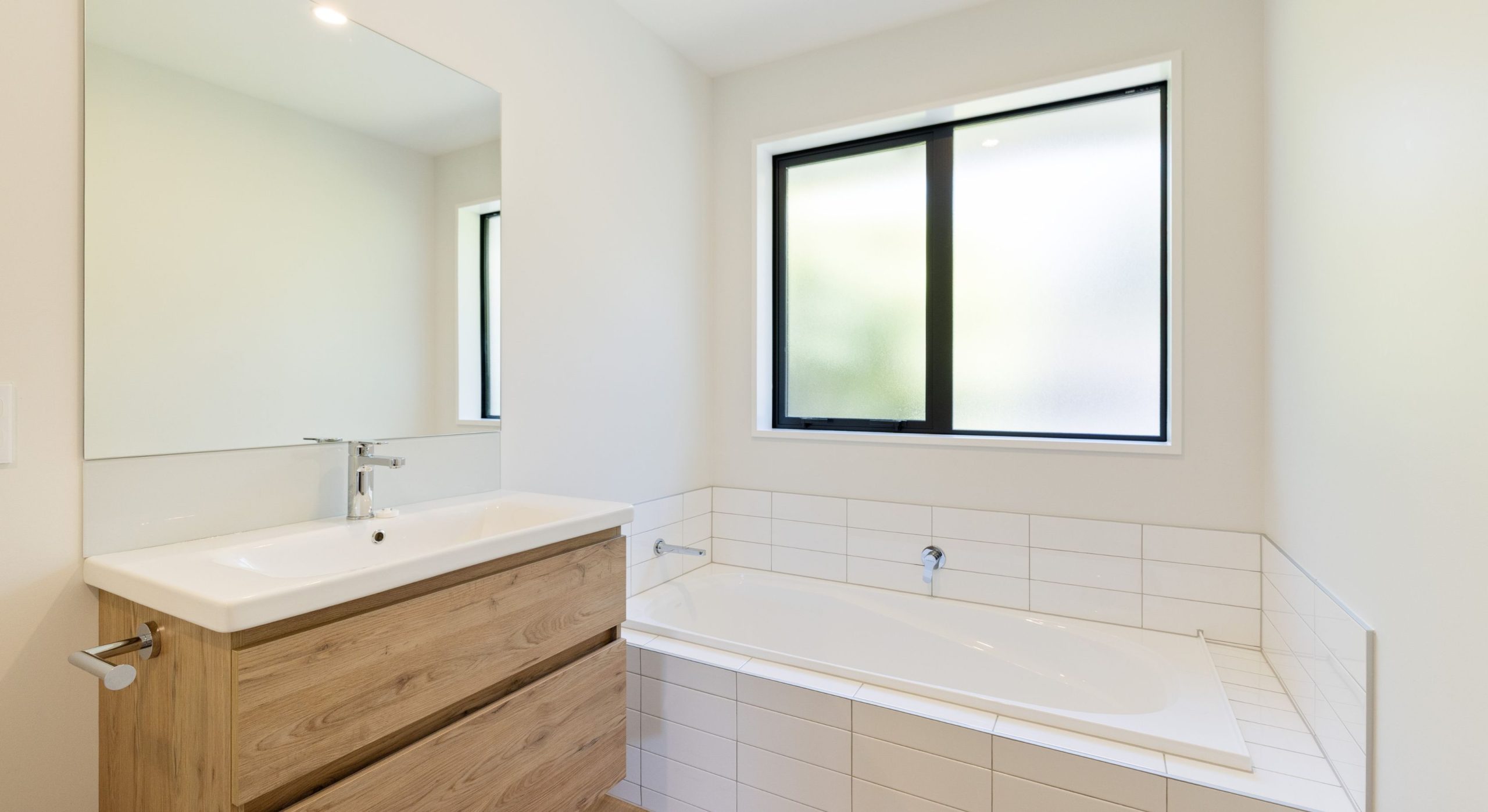 sleek modern bathroom with back to wall bath feature