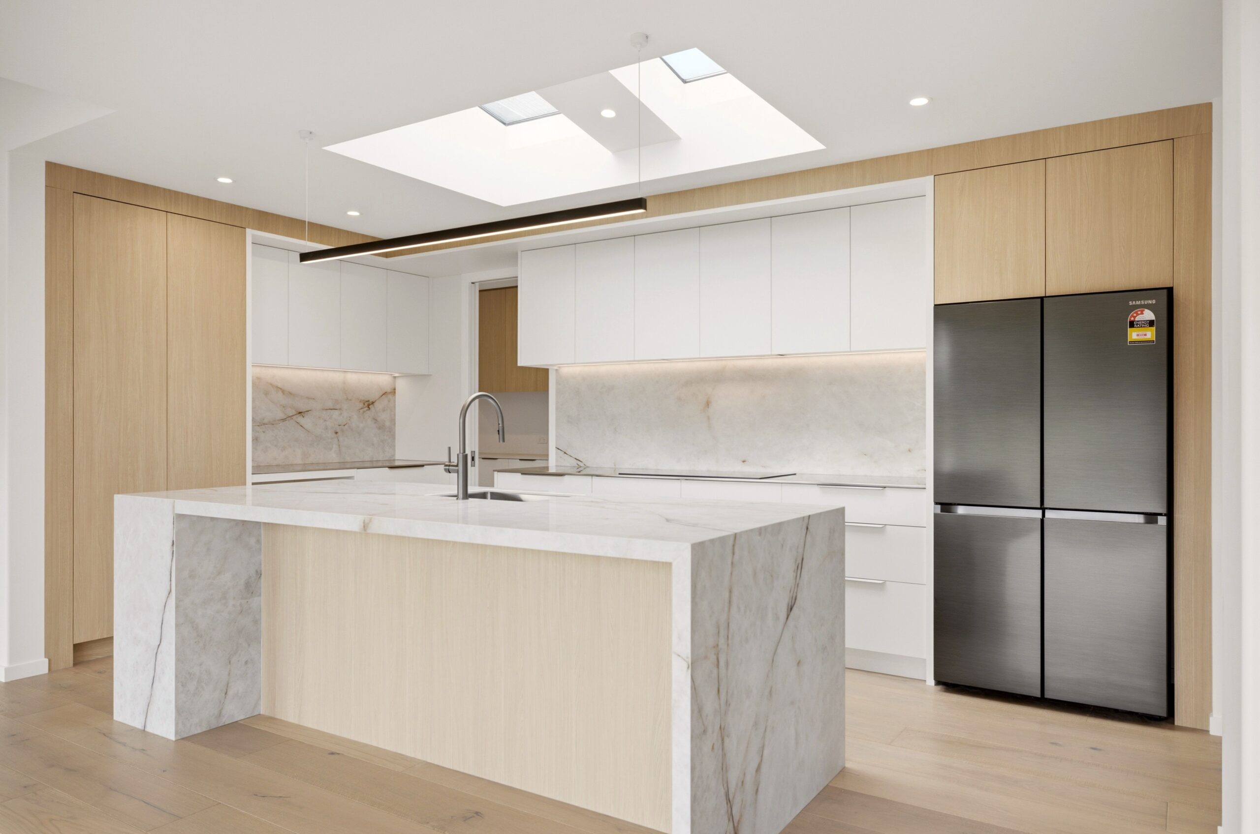 Wanaka plan, Hallmark Homes West Melton. Waterfall-edge stone island with undermount sink and pendant lighting.