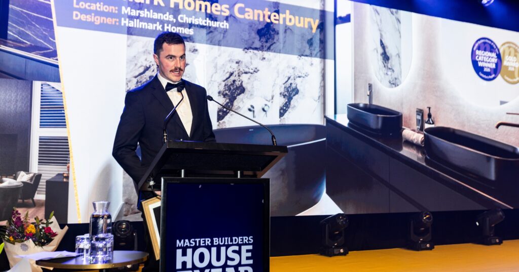 Paddy speaking on stage after Hallmark Homes Canterbury's House of the Year Gold Award and Category Winner win for their Marshlands, Christchurch build